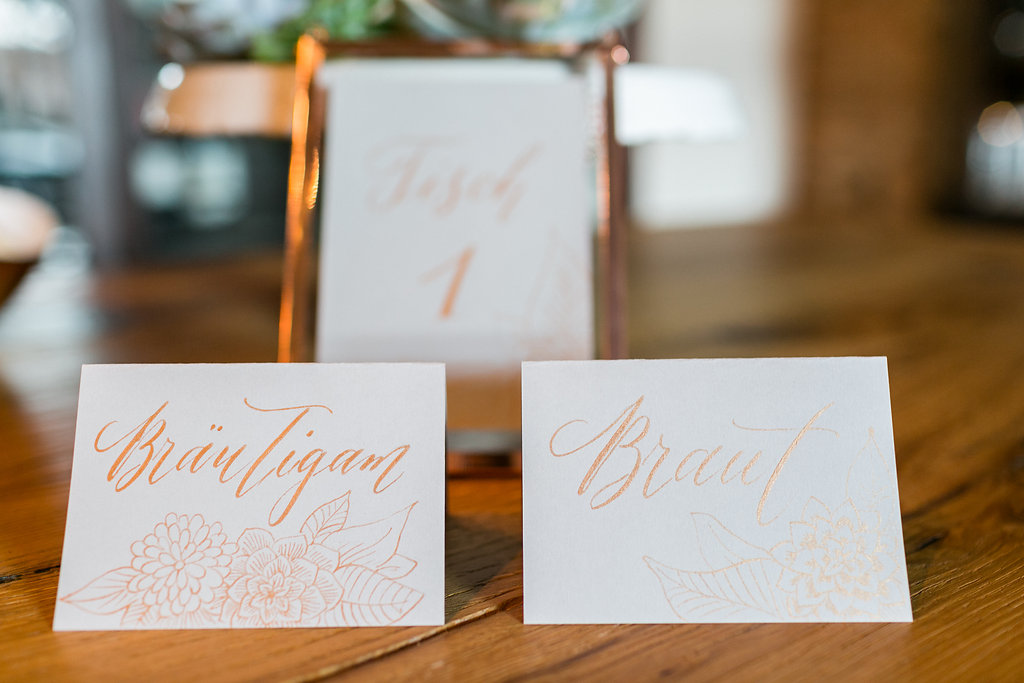 Hochzeitseinladung mit Illustrationen und moderner Kalligrafie in Kupfer und grau. Design Nicnillas Ink