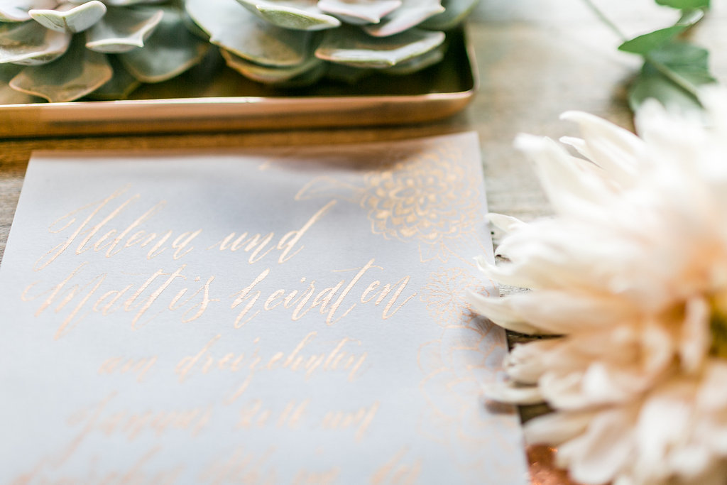 Hochzeitseinladung mit Illustrationen und moderner Kalligrafie in Kupfer und grau. Design Nicnillas Ink