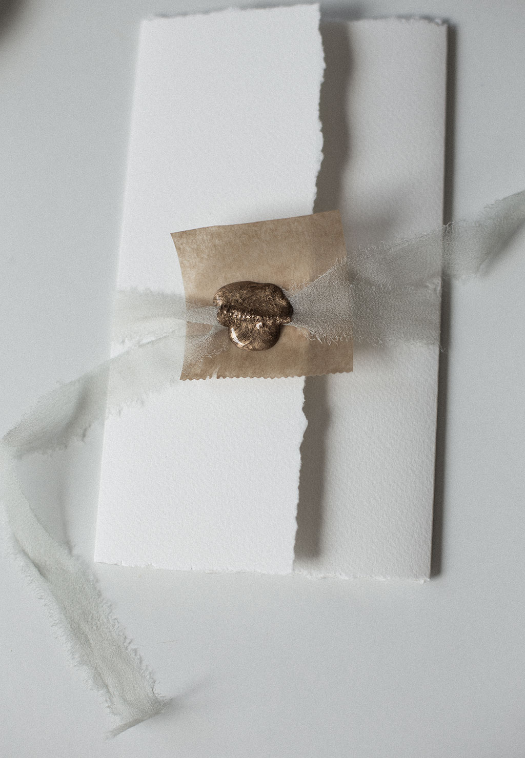 Sealing a wedding invitation with silk ribbon and a way seal.