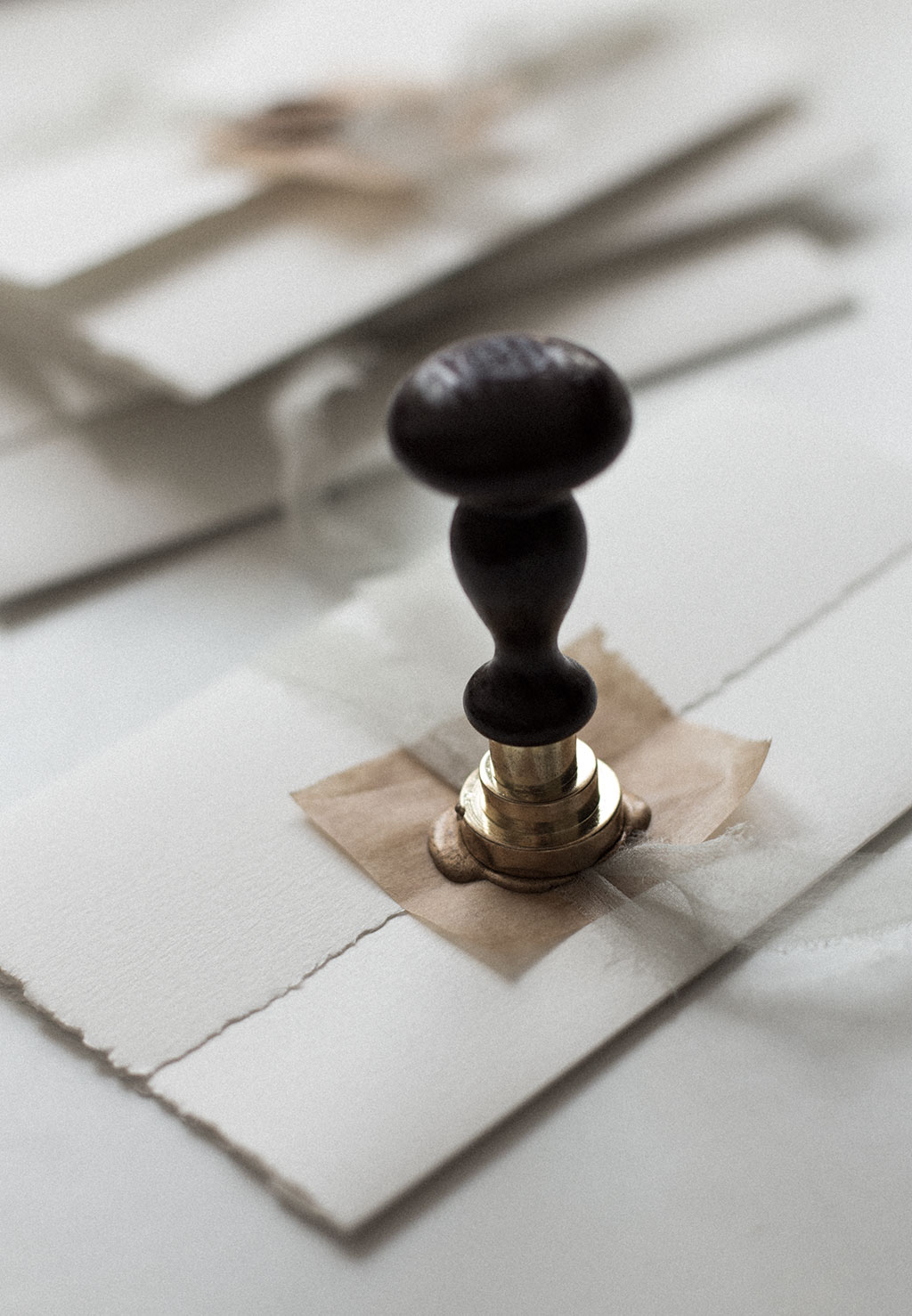 Sealing a wedding invitation with silk ribbon and a way seal.