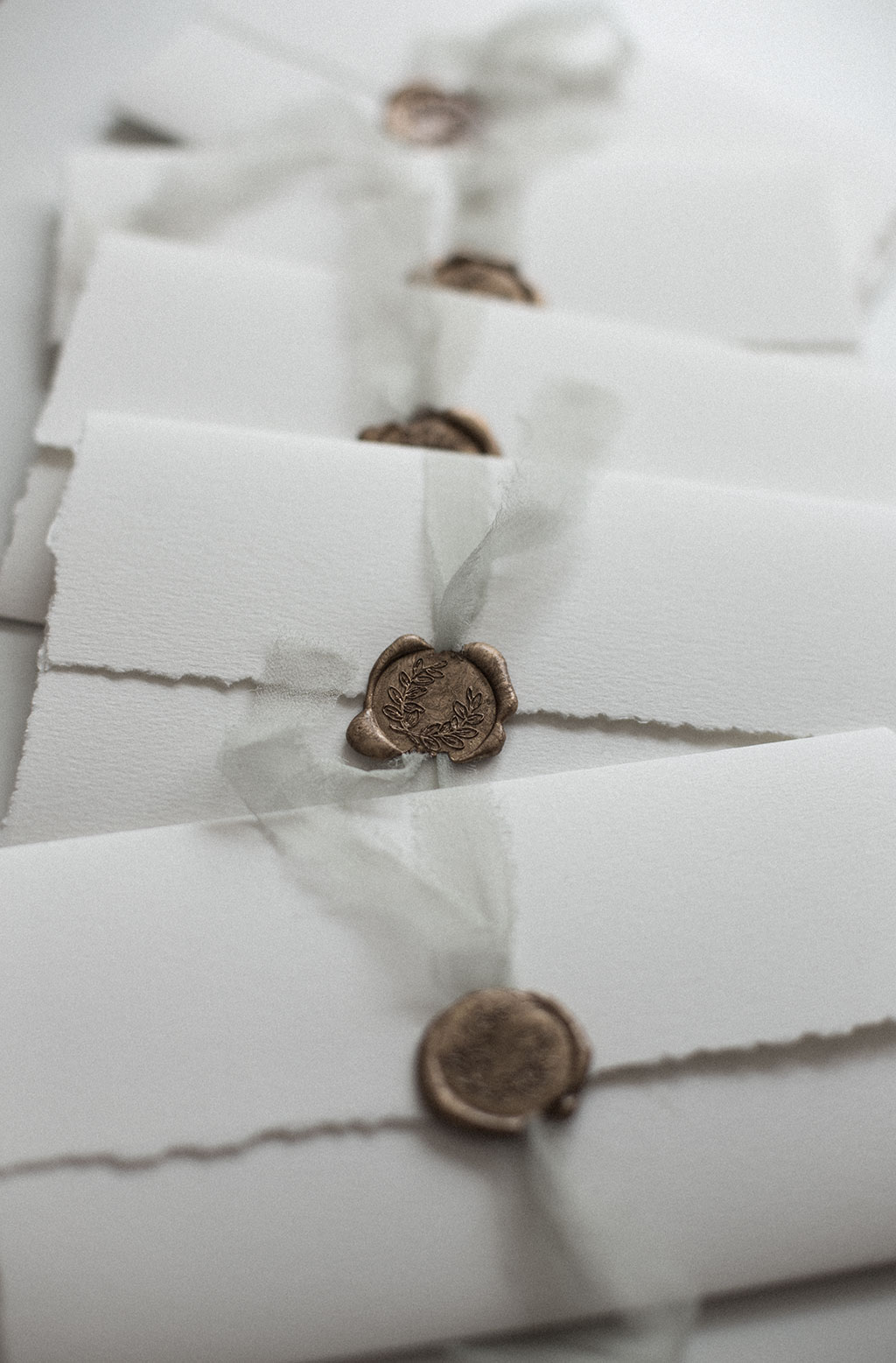 Sealing a wedding invitation with silk ribbon and a way seal.